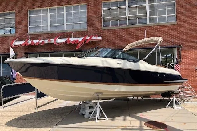 The Image of 2025 Chris-Craft Sportster 25 boat displayed outside a brick building. - 0