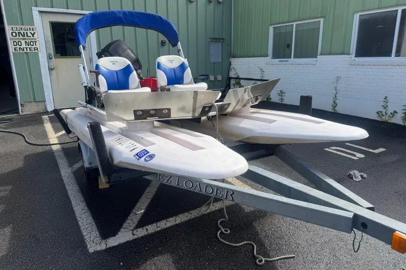 The Image of 2009 CraigCat custom boat on trailer, parked outside green building. - 0