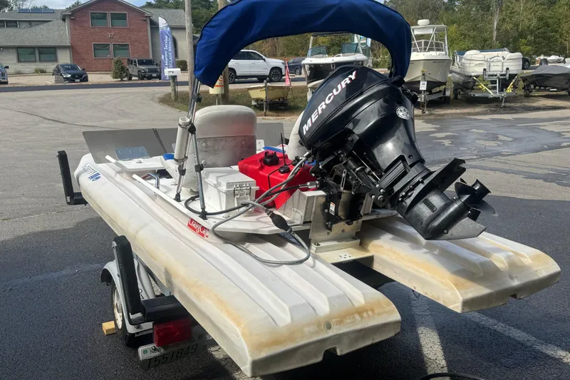 Slide: The Image of 2009 CraigCat custom boat with Mercury engine on trailer in parking lot. - 2