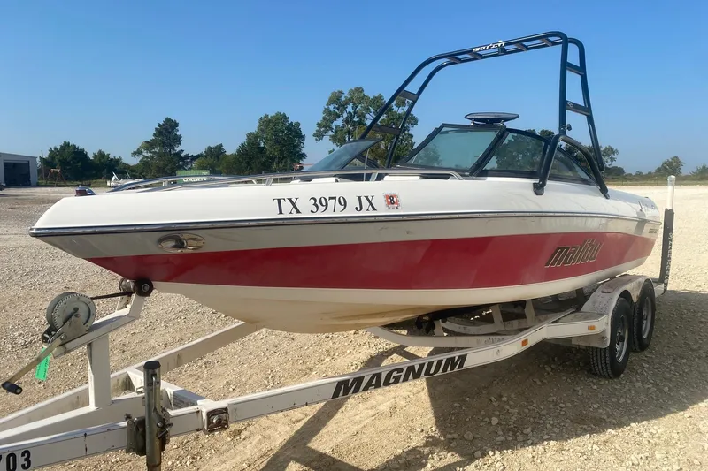 Slide: The Image of 2003 Malibu Sunsetter 21 XTi boat on trailer, red and white design, parked outdoors. - 2