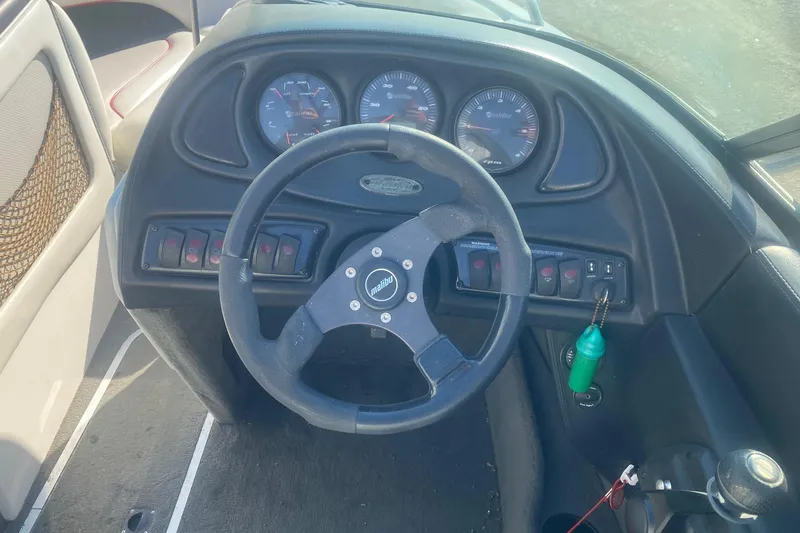 Slide: The Image of 2003 Malibu Sunsetter 21 XTi boat dashboard with steering wheel and gauges. - 5