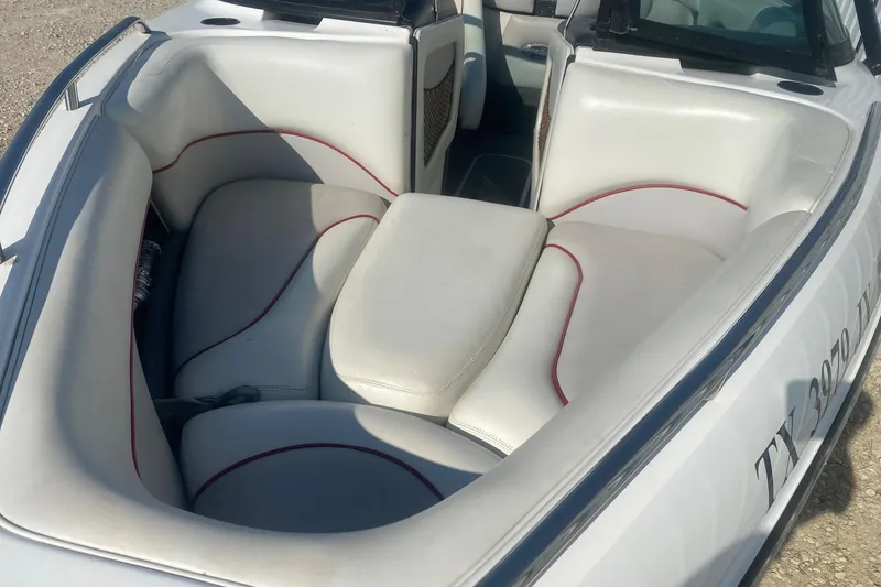 Slide: The Image of 2003 Malibu Sunsetter 21 XTi boat interior with white seating and red accents. - 9