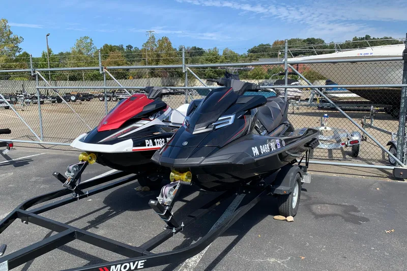 The Image of Two Yamaha WaveRunner FX Cruiser HO jet skis on trailers in a parking lot. - 1