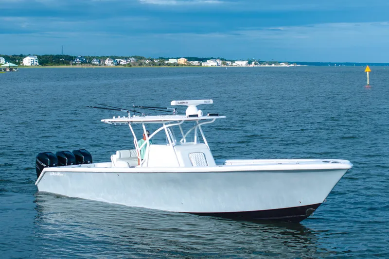 The Image of 2012 SeaHunter 37 Tournament boat on calm water, featuring triple outboard engines. - 1