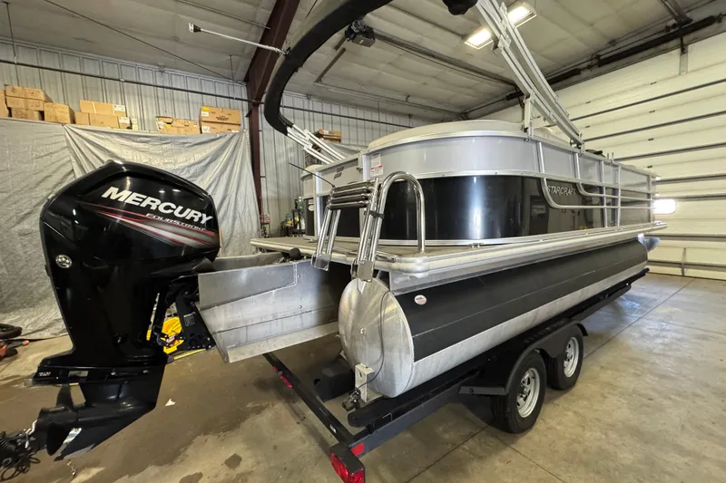 Slide: The Image of 2017 Starcraft EX 21 R pontoon boat with Mercury outboard motor in a garage. - 3