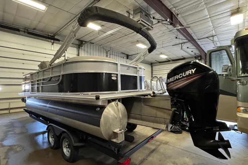 Slide: The Image of 2017 Starcraft EX 21 R pontoon boat with Mercury outboard motor in a garage. - 5