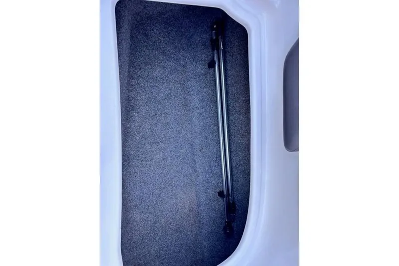 Slide: The Image of Storage compartment of a 2013 Yamaha Boats AR192, featuring a carpeted interior and metal support bars. - 14