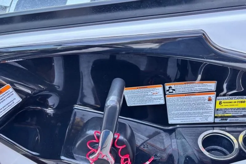 Slide: The Image of Control panel of a 2013 Yamaha Boats AR192 with safety labels and cup holders. - 17