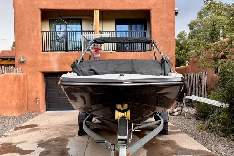 Slide: The Image of 2013 Yamaha AR192 boat on trailer in front of adobe-style house. - 2