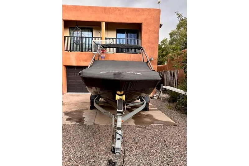 Slide: The Image of 2013 Yamaha AR192 boat on trailer, covered, parked in front of a house. - 3