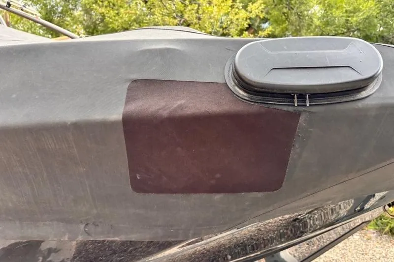 Slide: The Image of 2013 Yamaha AR192 boat cover with patch and vent, surrounded by greenery. - 36