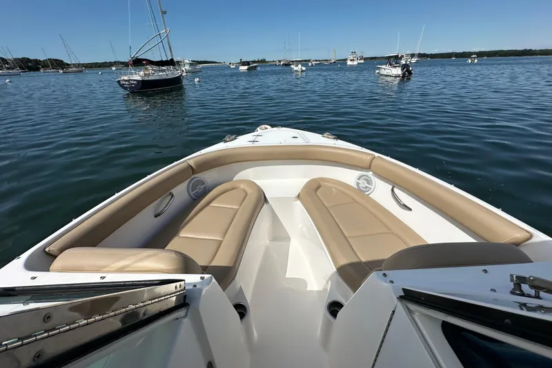 Slide: The Image of 2015 Pursuit DC 265 Dual Console boat with tan seating, anchored in a calm bay. - 10