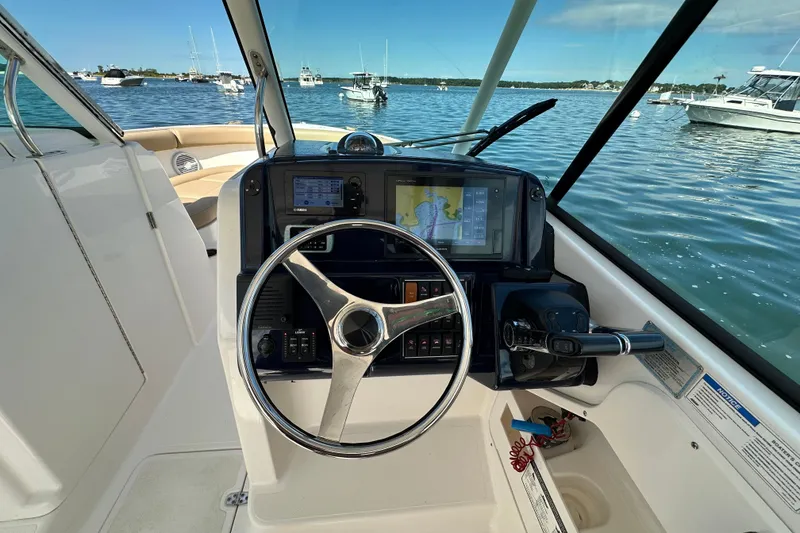 Slide: The Image of 2015 Pursuit DC 265 Dual Console boat helm with steering wheel and navigation system. - 12