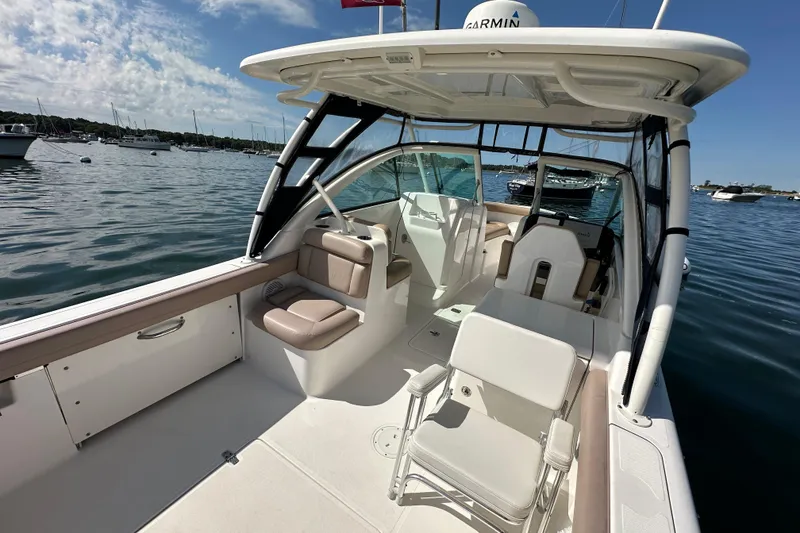 Slide: The Image of 2015 Pursuit DC 265 Dual Console boat on calm water, featuring spacious seating and modern design. - 16