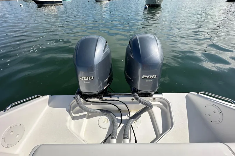 Slide: The Image of Twin Yamaha 200 engines on a 2015 Pursuit DC 265 Dual Console boat in calm waters. - 18