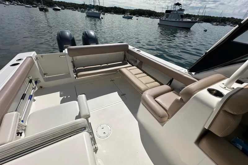 Slide: The Image of 2015 Pursuit DC 265 Dual Console boat interior with seating, docked in a marina. - 22