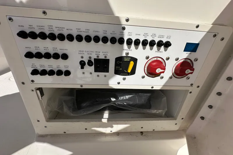 Slide: The Image of Control panel of a 2015 Pursuit DC 265 Dual Console boat with various switches and dials. - 23