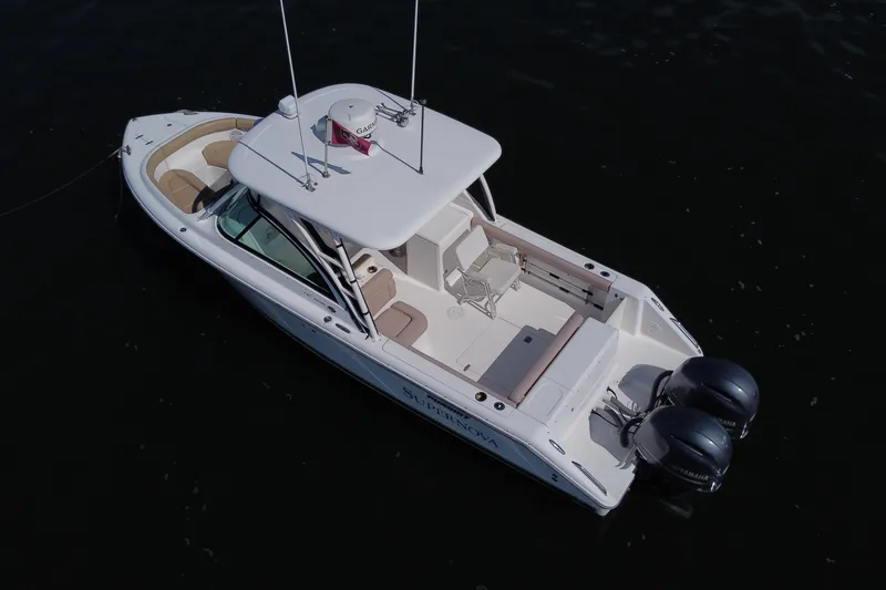 Slide: The Image of 2015 Pursuit DC 265 Dual Console boat on dark water, aerial view. - 5