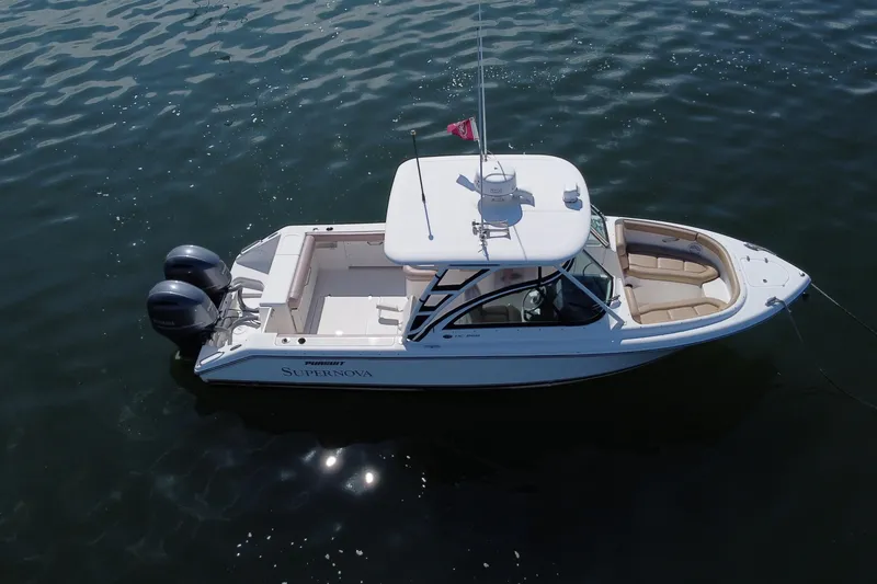 Slide: The Image of 2015 Pursuit DC 265 Dual Console boat on calm water, aerial view. - 7
