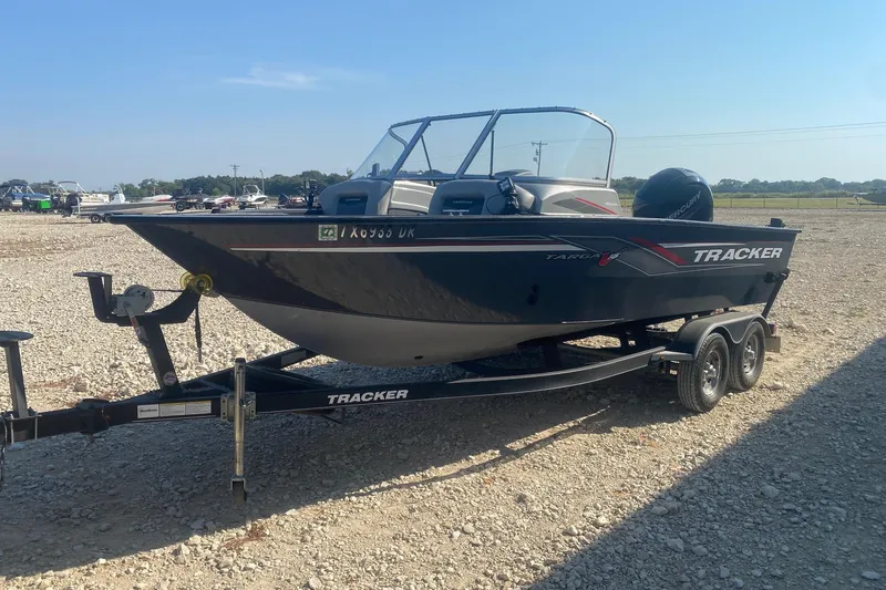 Slide: The Image of 2017 Tracker Targa V-18 WT boat on trailer in gravel lot, sunny day. - 2