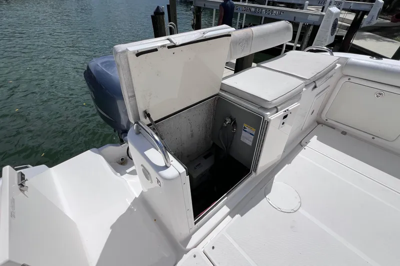 Slide: The Image of 2005 Century 3200 Walk-Around boat with open storage compartment at dockside. - 11