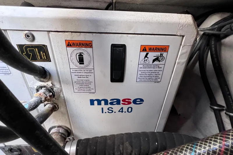 Slide: The Image of Mase I.S. 4.0 generator with warning labels in a 2005 Century 3200 Walk-Around boat. - 13