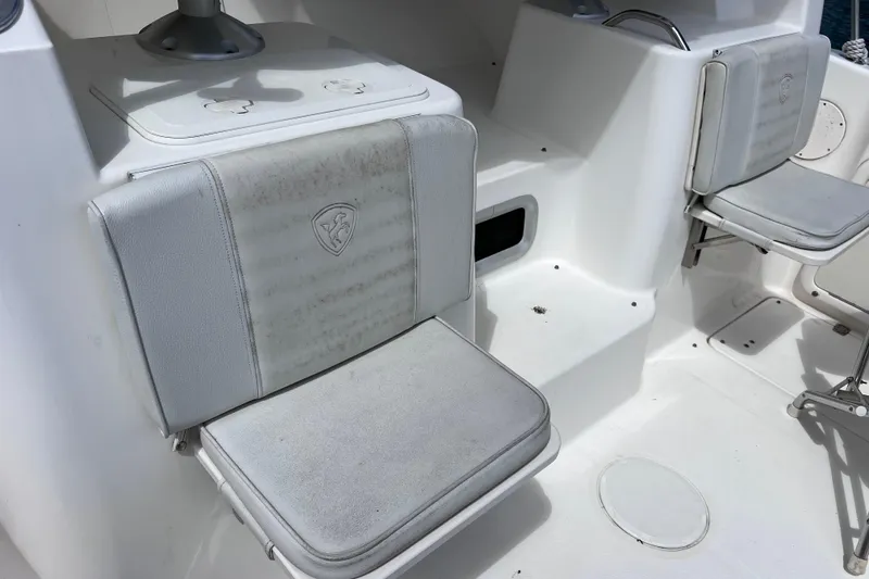 Slide: The Image of 2005 Century 3200 Walk-Around boat interior with cushioned seating and storage compartments. - 16