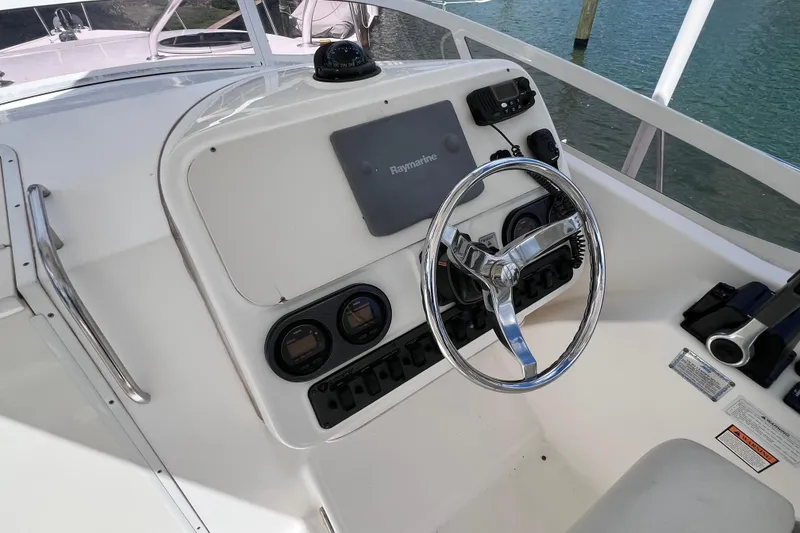 Slide: The Image of Helm of 2005 Century 3200 Walk-Around boat with steering wheel and navigation equipment. - 25