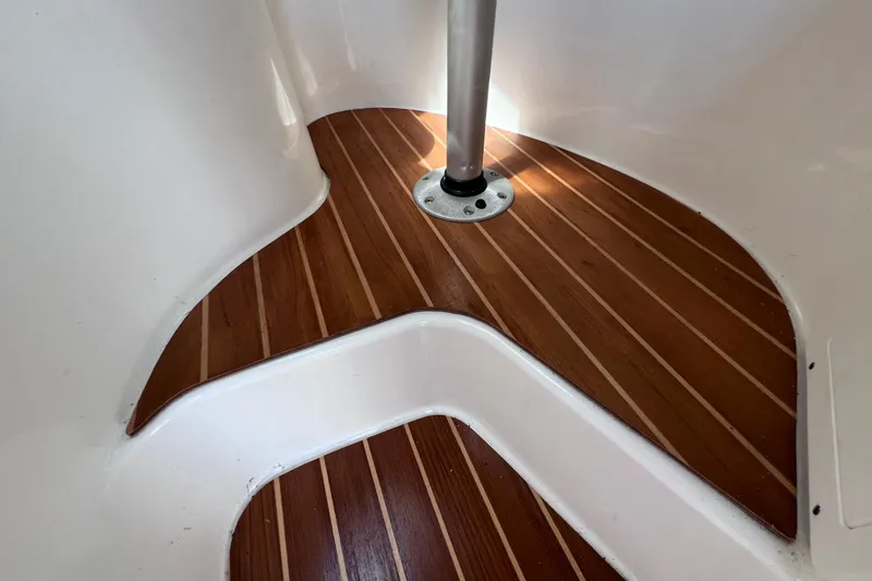 Slide: The Image of 2005 Century 3200 Walk-Around boat interior with wooden flooring and metal pole. - 49