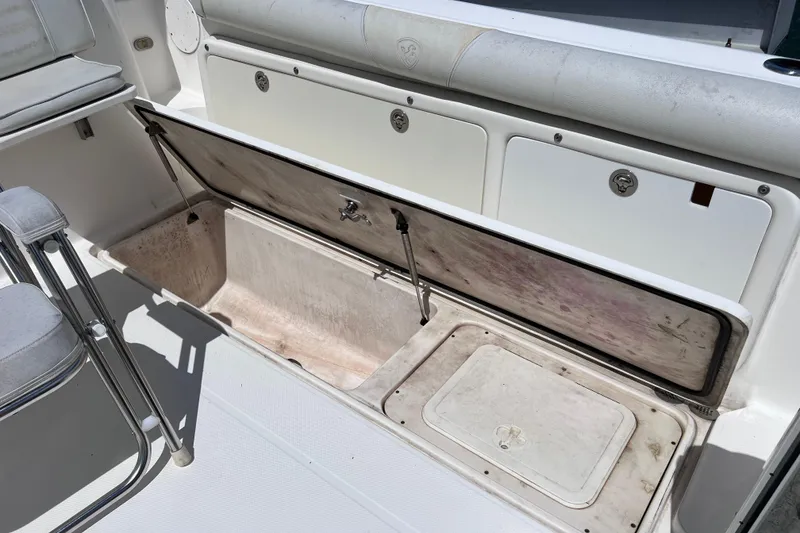Slide: The Image of 2005 Century 3200 Walk-Around boat storage compartment with open hatch and seating area. - 57