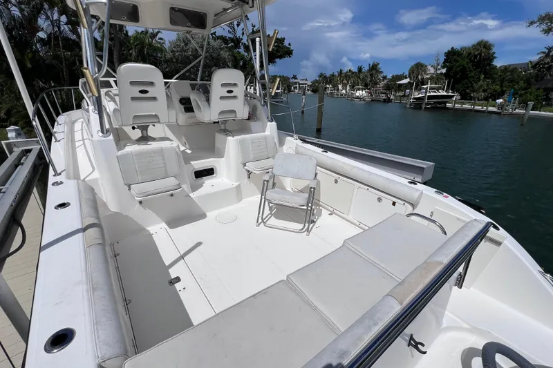 Slide: The Image of 2005 Century 3200 Walk-Around boat with spacious deck and seating, docked by the water. - 6