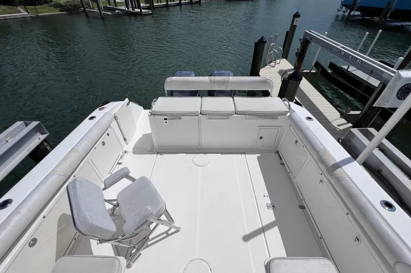 Slide: The Image of 2005 Century 3200 Walk-Around boat deck with seating, docked by the water. - 8