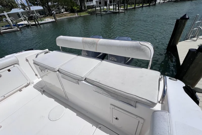 Slide: The Image of 2005 Century 3200 Walk-Around boat with cushioned seating, docked by the water. - 9