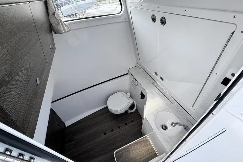 Slide: The Image of 2026 Sportsman Heritage 321 Center Console boat interior with toilet and sink. - 12
