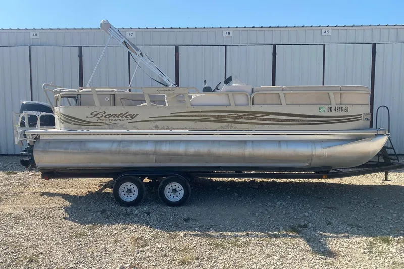 The Image of 2008 Bentley Pontoons Prestige 223LC on trailer, parked outside storage units. - 0