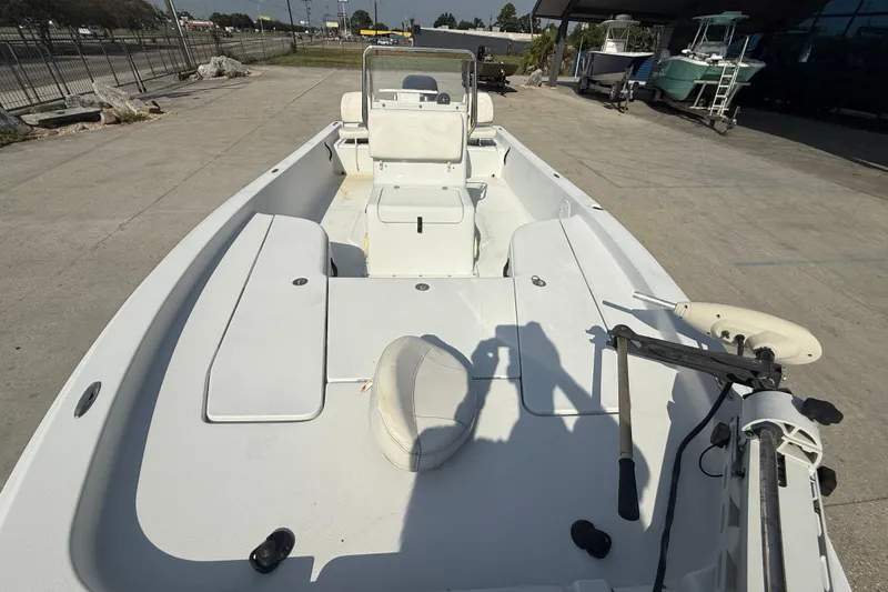 Slide: The Image of 2008 Champion 220 Bay boat with spacious deck and seating, parked outdoors. - 11