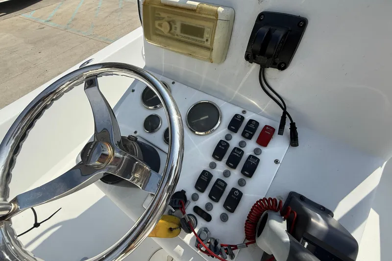 Slide: The Image of 2008 Champion 220 Bay boat dashboard with steering wheel and control panel. - 15