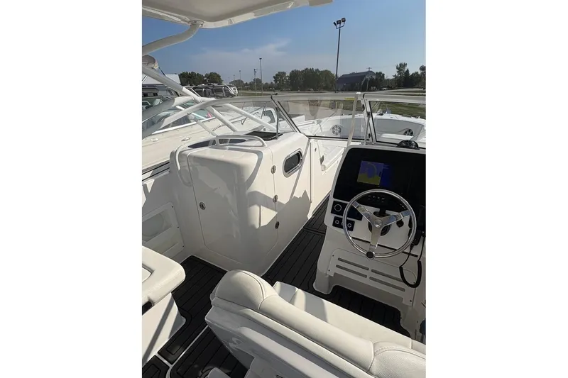 Slide: The Image of 2023 Edgewater 248 CX boat interior with steering wheel and navigation display. - 12