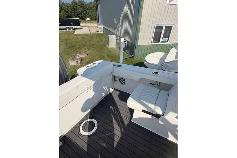 Slide: The Image of 2023 Edgewater 248 CX boat interior with white seating and deck view. - 14