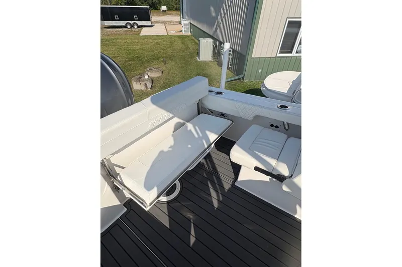 Slide: The Image of 2023 Edgewater 248 CX boat interior with white seating and deck view. - 15