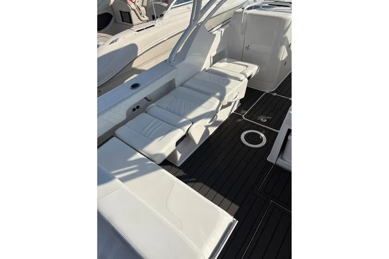 Slide: The Image of 2023 Edgewater 248 CX boat interior with white seating and sleek black flooring. - 16