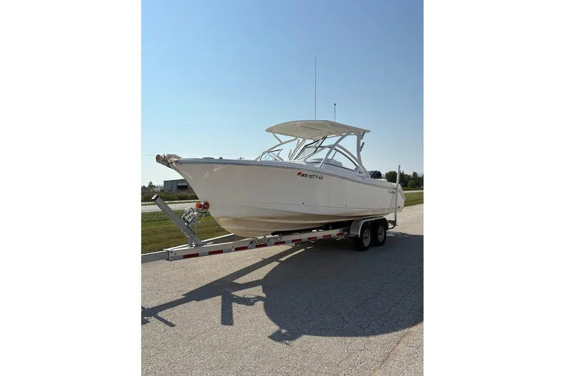 Slide: The Image of 2023 Edgewater 248 CX boat on trailer under clear blue sky. - 2