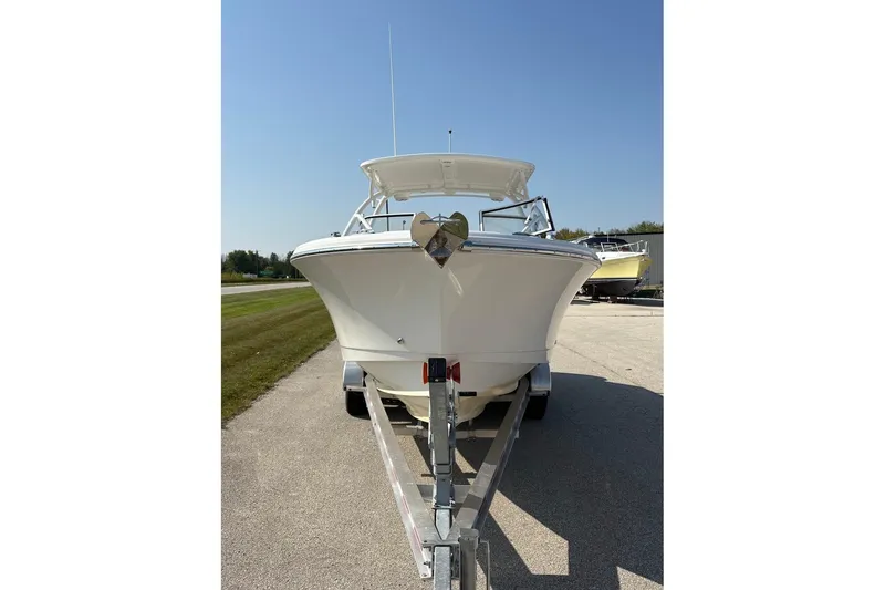 Slide: The Image of 2023 Edgewater 248 CX boat on trailer under clear blue sky. - 3