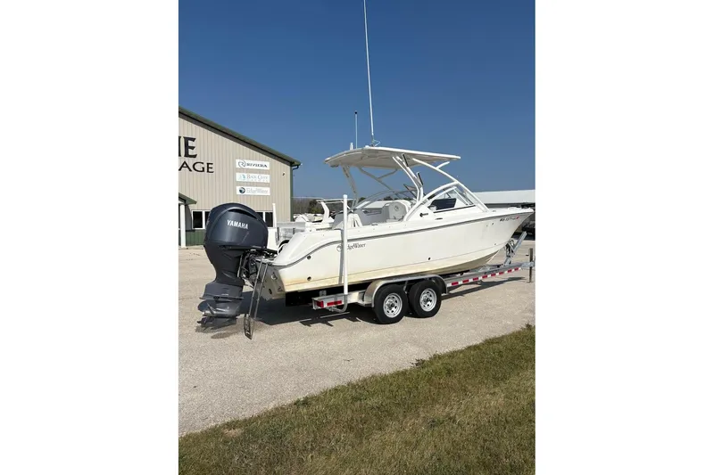 Slide: The Image of 2023 Edgewater 248 CX boat on trailer with Yamaha engine, parked outdoors. - 5