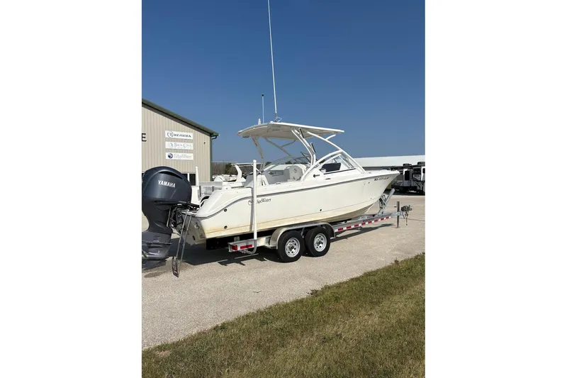 Slide: The Image of 2023 Edgewater 248 CX boat on trailer with Yamaha engine, parked outdoors. - 6
