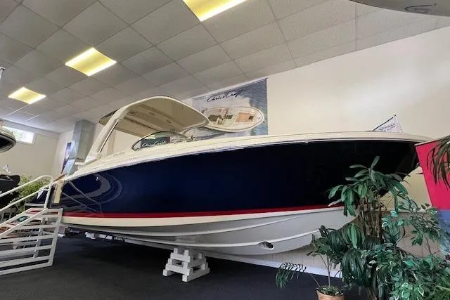 Slide: The Image of 2025 Chris-Craft Launch 28 GT boat displayed indoors, featuring sleek design and elegant blue hull. - 1