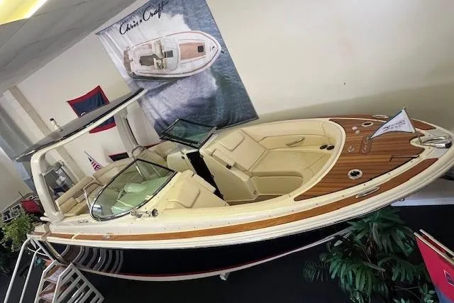 Slide: The Image of 2025 Chris-Craft Launch 28 GT boat displayed indoors, featuring elegant design and luxurious seating. - 2