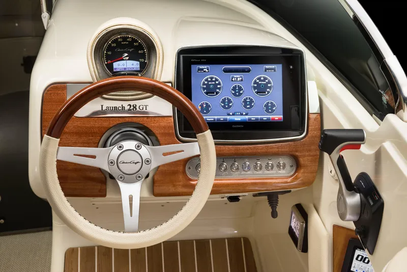 Slide: The Image of 2024 Chris-Craft Launch 28 GT dashboard with wooden steering wheel and digital display. - 5