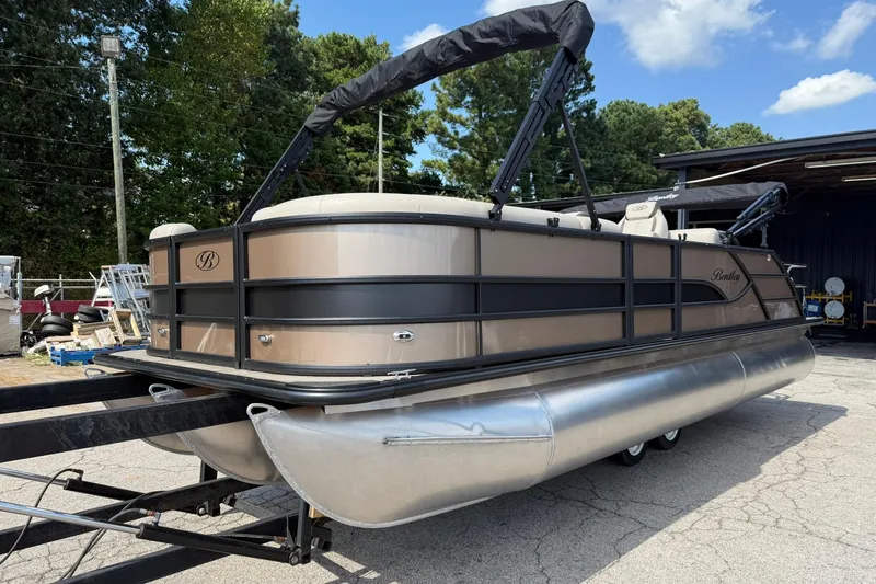 Slide: The Image of 2025 Bentley Pontoons Legacy 223 QSB on trailer, parked outdoors, under clear sky. - 2