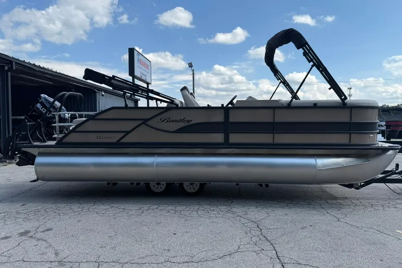 Slide: The Image of 2025 Bentley Pontoons Legacy 223 QSB pontoon boat parked outdoors under a blue sky. - 4